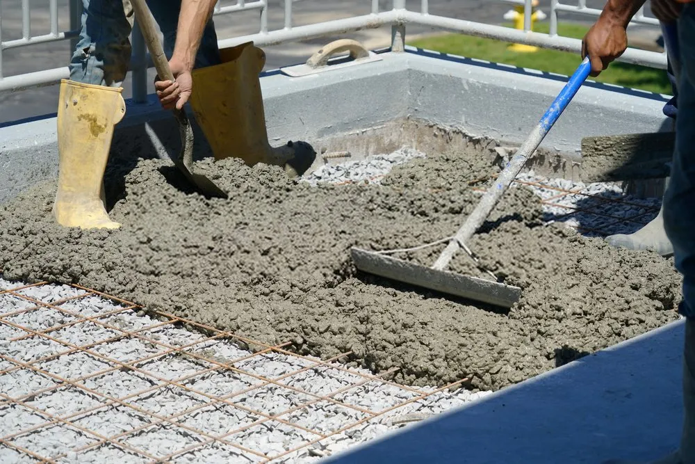 Naples Concrete Solutions pros spreading concrete around the frame